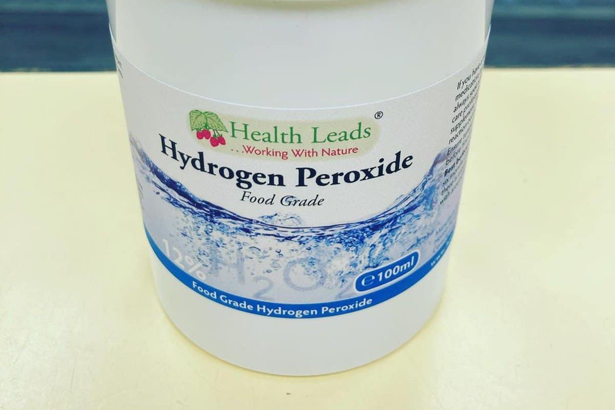 a can of hydrogen peroxide on a white shelf